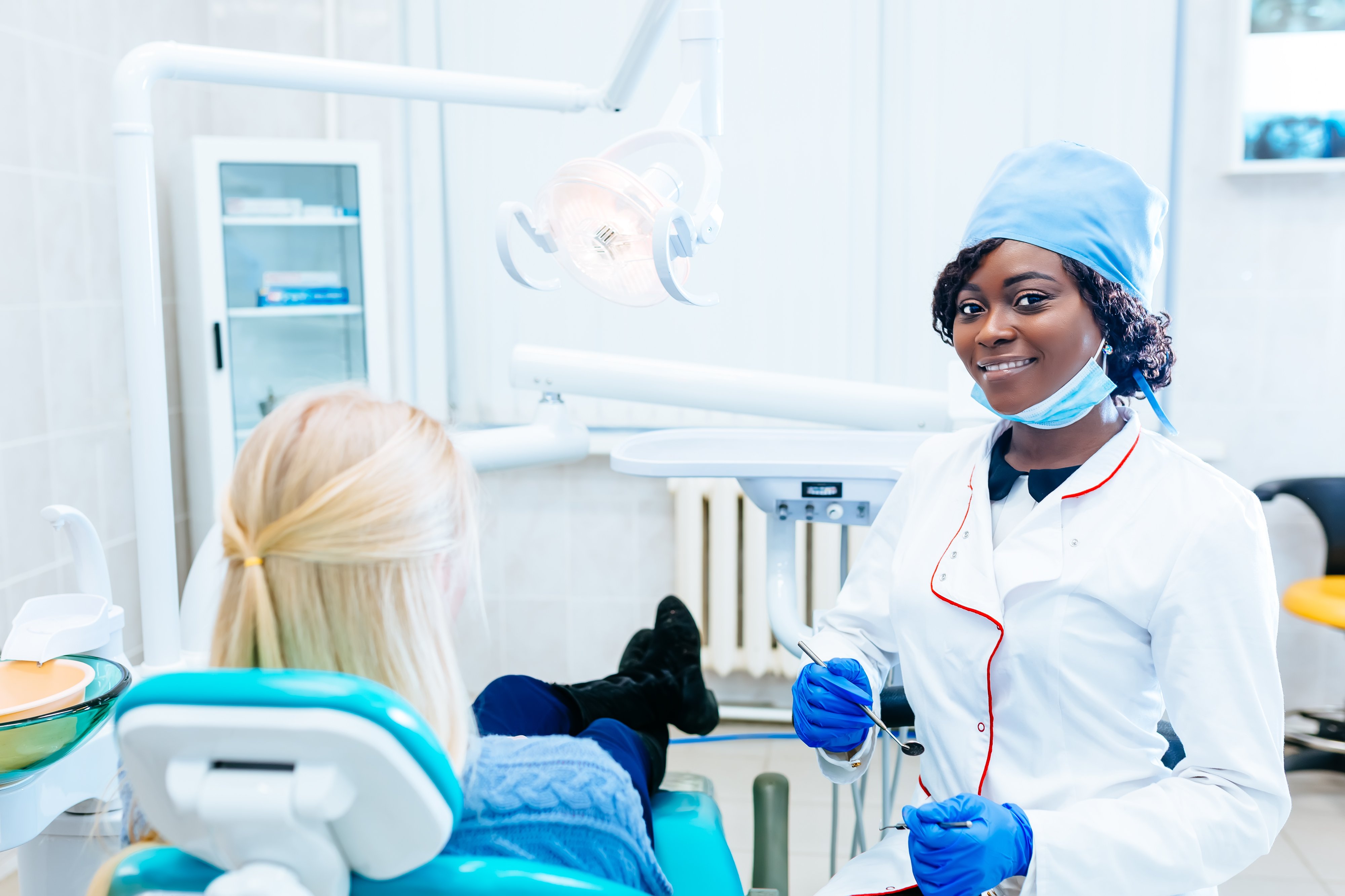 African american female dentist treating patient at clinic. Dental clinic concept