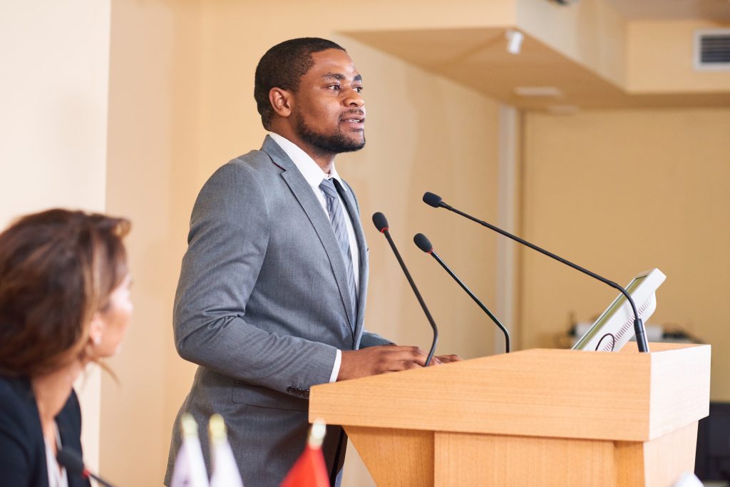 Young African-american male speaker talking in microphone